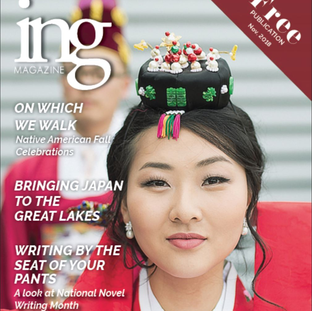 A magazine front cover featuring a young man and woman in traditional Korean attire.